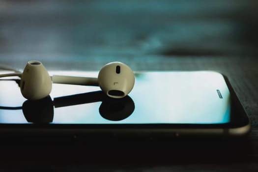 close up headphone stack on phone in black color tone, new headphone modern design device of phone technology