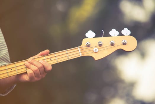 close up on man play on bass guitar