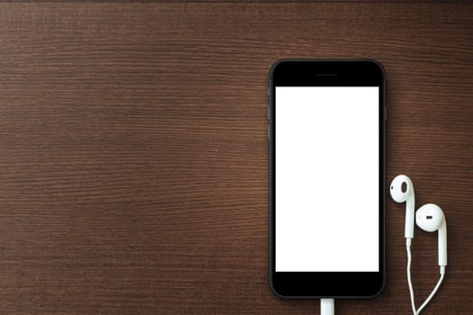 phone blank screen and headphone on wood table, mockup new phone style