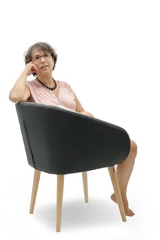 a portrait of brunette mature woman relaxing in armchair