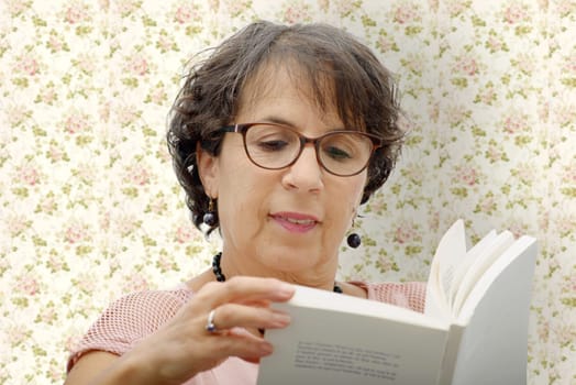 a mature brunette woman reading a book
