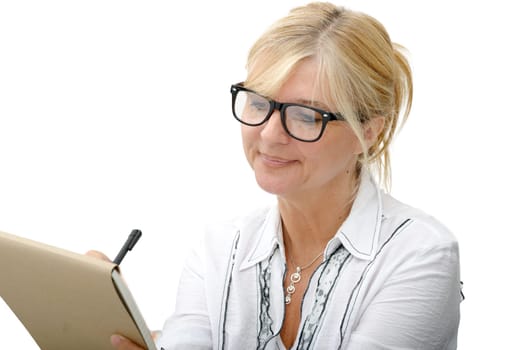 a mature woman writing on a notebook