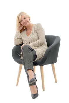 a portrait of blond mature woman relaxing in armchair
