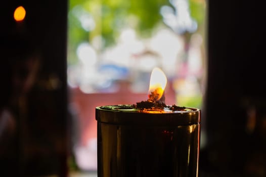 Burning oil lamps at religious temple in Thailand