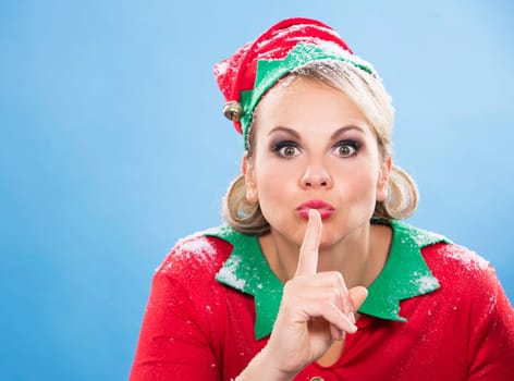 blonde woman wearing elf christmas costume on blue background