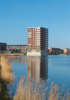 modern apartment building reflected in a lake