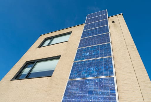 modern house in the netherlands with a row of solar panels at the its facade