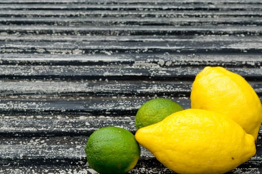 Raw textured black Background backdrop with lemon and lime and copy space outdoor