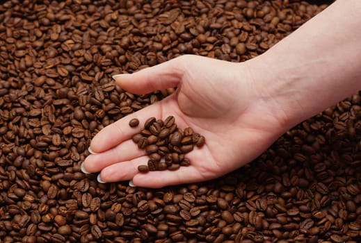 Women's hand and fresh coffee beans