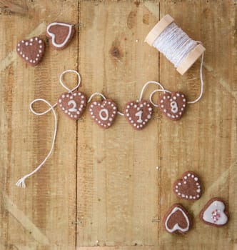 Small biscuit hearts at the turn of the year on a rustic background made of wood