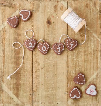 Small biscuit hearts at the turn of the year on a rustic background made of wood
