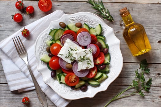 Greek salad with tomatoes, feta cheese, cucumbers, onions and olives