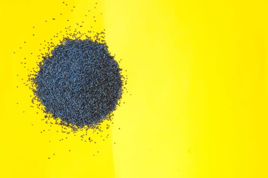 Poppy seeds isolated on yellow background poppy seed, pile of poppy seeds