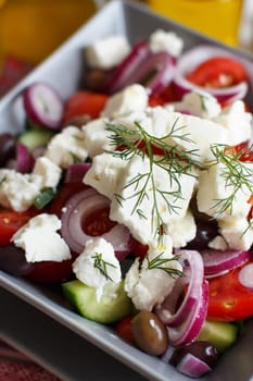 Greek salad with tomatoes, feta cheese, cucumbers, onions and olives