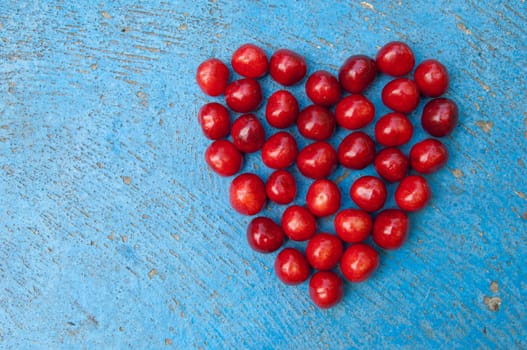 Heart shaped cherries on blue background, cherry heart, isolated