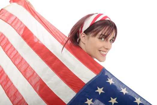 a pretty young woman isolated holding an American Flag, back view