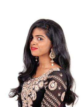 A gorgeous young Indian woman in a original Indian dress and long black.hair standing in a portrait, isolated for white background..
