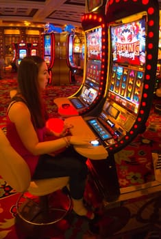 Las Vegas, United States of America - May 06, 2016: Concentrated girl playing slot machines in the Excalibur Hotel and Casino