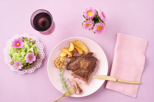 Steak with salad womanly styled on pink table