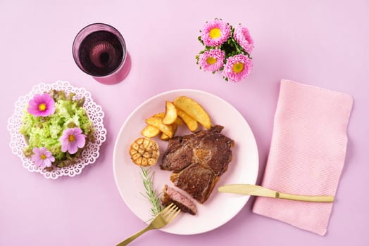 Steak with salad womanly styled on pink table
