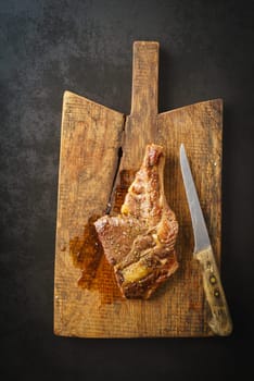 Seared dry aged rib eye steak on rustic wooden board