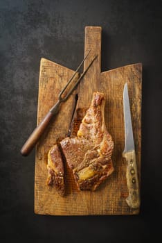 Seared dry aged rib eye steak on rustic wooden board