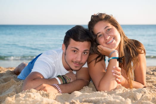 Happy teenage couple posing in the beach