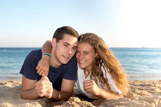Happy teenage couple posing in the beach
