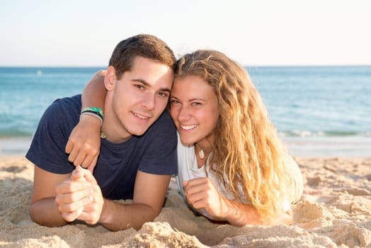 Happy teenage couple posing in the beach