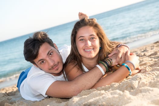 Happy teenage couple posing in the beach