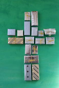 many small gifts on green wood form a cross