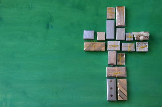 many small gifts on green wood form a cross