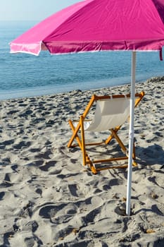 Beach chairs in front of the calm the sea at sunrise