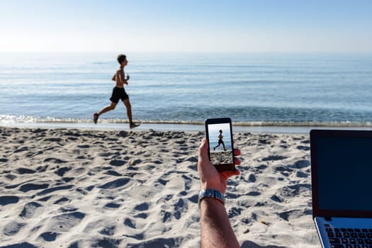 Businessman on the beach working with notebook and smartphone
