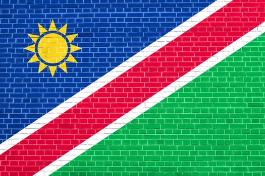 Namibian national official flag. African patriotic symbol, banner, element, background. Flag of Namibia on brick wall texture background