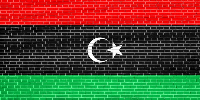 Libyan national official flag. African patriotic symbol, banner, element, background. Flag of Libya on brick wall texture background