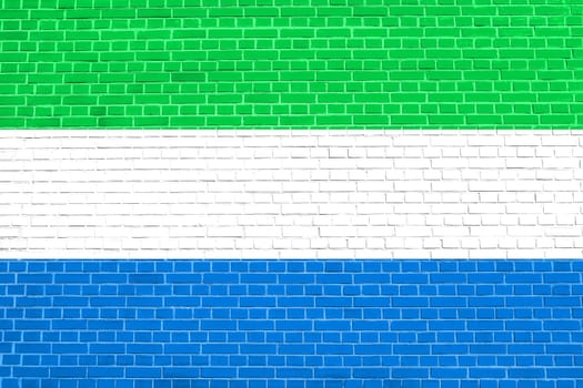 Sierra Leonean national official flag. African patriotic symbol, banner, element, background. Flag of Sierra Leone on brick wall texture background