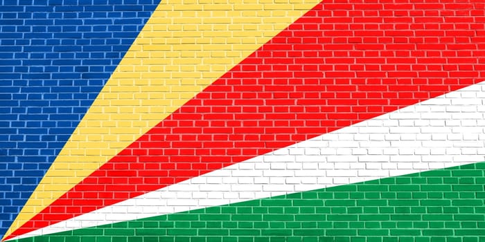 Seychellois national official flag. African patriotic symbol, banner, element, background. Flag of Seychelles on brick wall texture background
