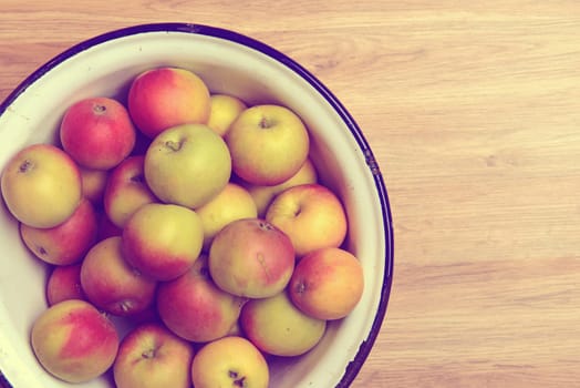 apples in bowl on wooden ground from above