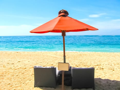 Two chairs and umbrella on Bali tropical beach