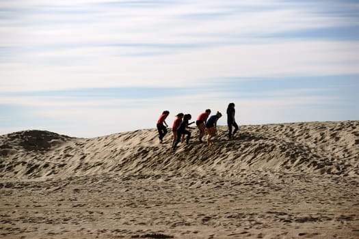 Long Beach,United States - December 26,2015: A women's volleyball team is training endurance on the dunes on Long Beach beach on December 26,2015 in Long Beach.