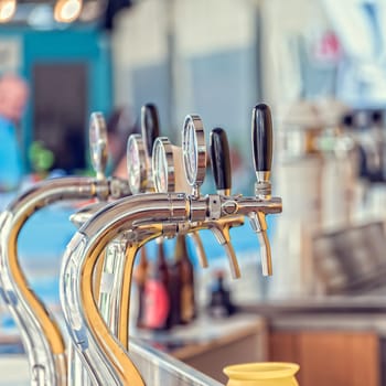 Draught beer taps and other beverages in a bar.