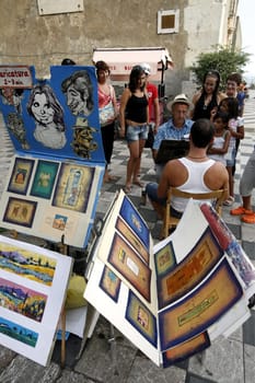 a Painter in the old Town of Taormina in Sicily in south Italy in Europe.