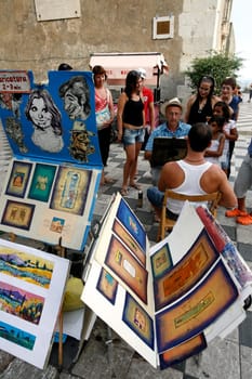 a Painter in the old Town of Taormina in Sicily in south Italy in Europe.