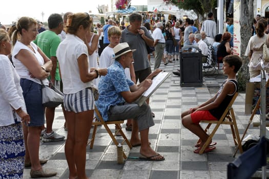 a Painter in the old Town of Taormina in Sicily in south Italy in Europe.