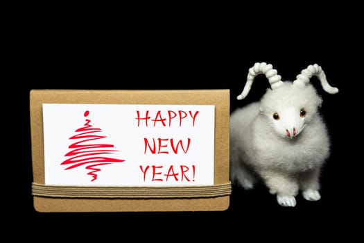 New Year greeting card or postcard with white goat or sheep toy the chinese symbol of 2015 year on black background