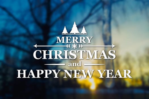 Merry Christmas and New Year greeting card on blurred tree and icicle at sunset blue colored background