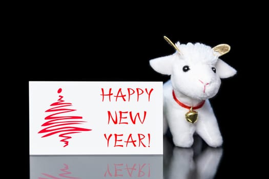 New Year greeting card or postcard with white goat or sheep toy the chinese symbol of 2015 year on black background