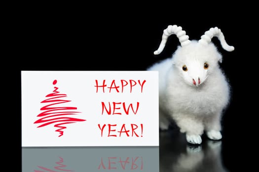 New Year greeting card or postcard with white goat or sheep toy the chinese symbol of 2015 year on black background
