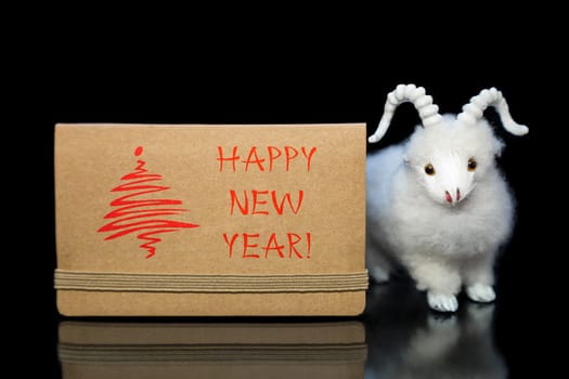 New Year greeting card or postcard with white goat or sheep toy the chinese symbol of 2015 year on black background